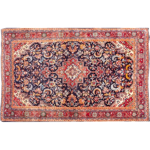 1375 - A Sarouk Rug,  the indigo field with a central brick red stepped pole medallion, all over palmette a... 