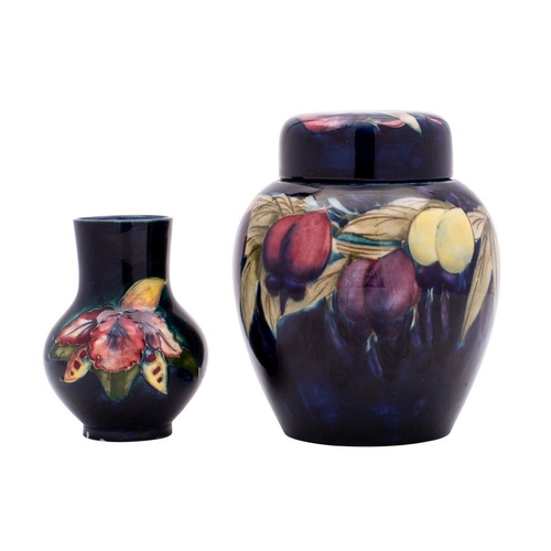 194 - A Moorcroft jar and cover and a vase, the former of oviform and tube lined in the Plum pattern on a ... 