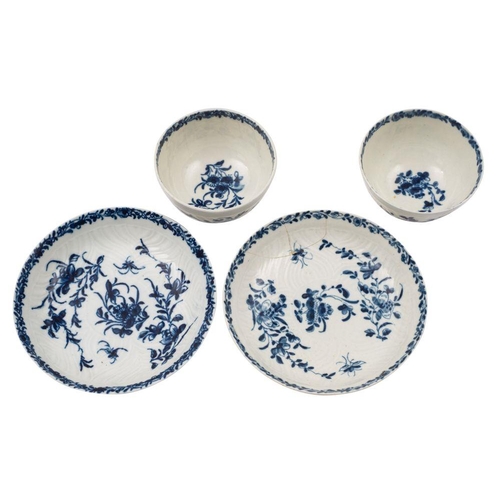 247 - A pair of First Period Worcester blue and white tea bowls and saucers in the Feather Mould Floral pa... 