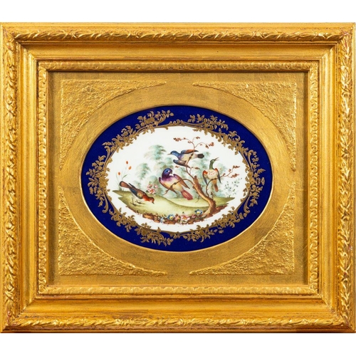 313 - A pair of Sèvres-style porcelain oval plaques each painted with exotic birds in a garden reserved wi... 