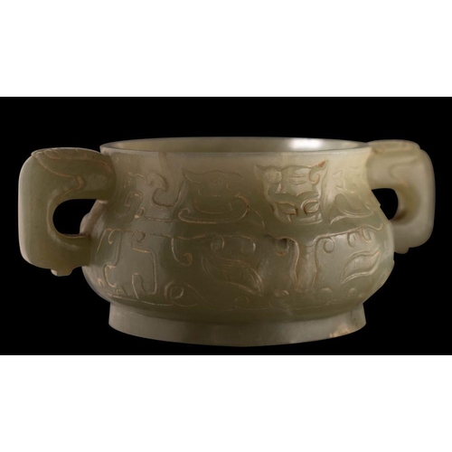 588 - A small Chinese jade censer in archaic style of bombe form with mythical beast handles, carved with ... 