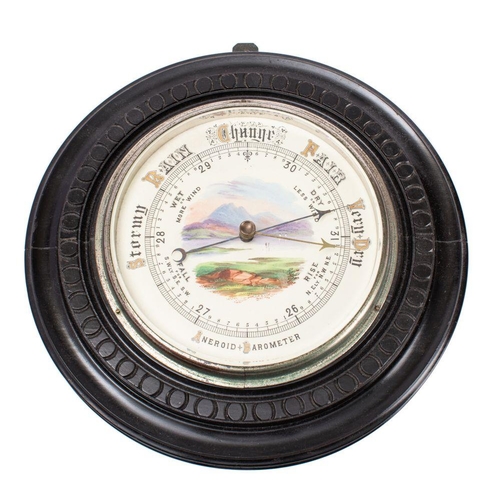 699 - An Edwardian ebonised aneroid barometer the round dial with a landscape scene to the centre, the rou... 