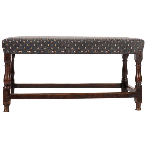 964 - An oak and upholstered long stool in 17th century taste, late 19th / early 20th century; the rectang... 