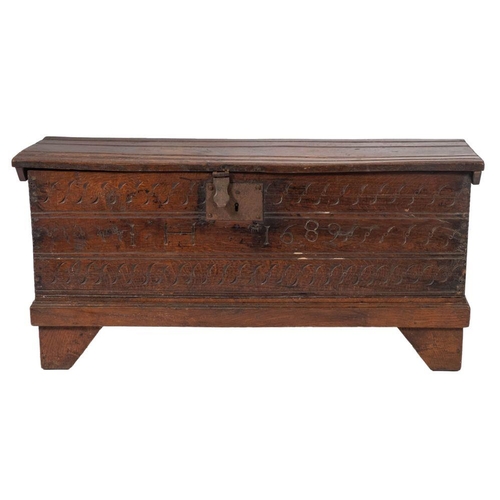 985 - A William and Mary oak coffer, dated 1689; the hinged top channelled to notched ends; the front with... 