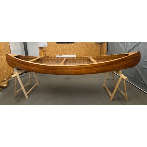 396 - An early 20th century Canadian cedar strip canoe: of traditional construction with three seats, one ... 