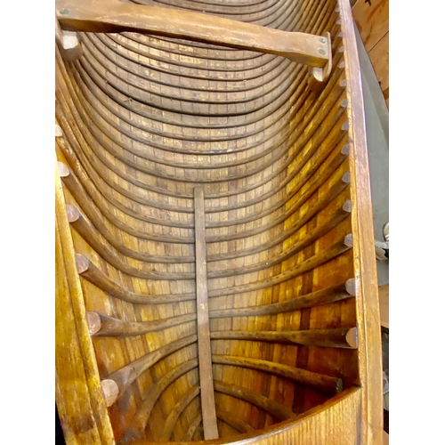 396 - An early 20th century Canadian cedar strip canoe: of traditional construction with three seats, one ... 