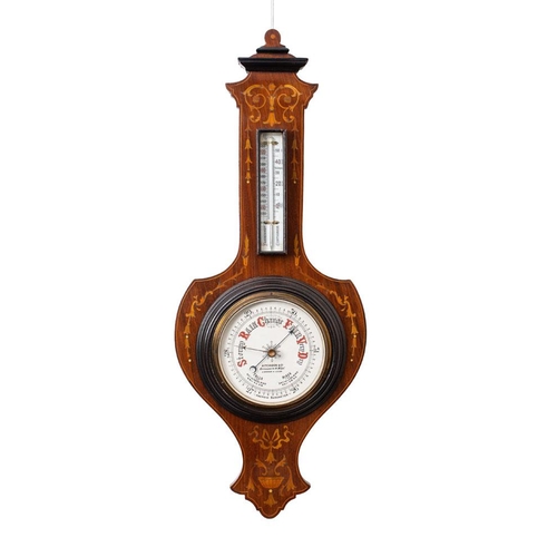 510 - A mahogany shield-shaped aneroid barometer the six-inch dial with usual barometer markings and signe... 