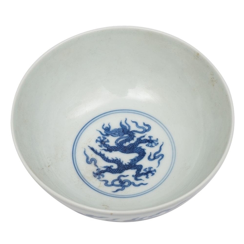 66 - A Chinese blue and white porcelain bowl the exterior painted with a pair of dragons amongst clouds, ... 