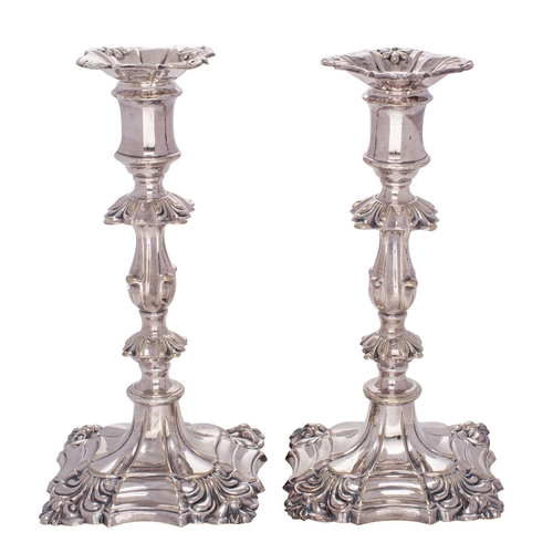 2006 - A pair of plated candlesticks in the George II taste with anthemion decoration and knopped stems, on... 