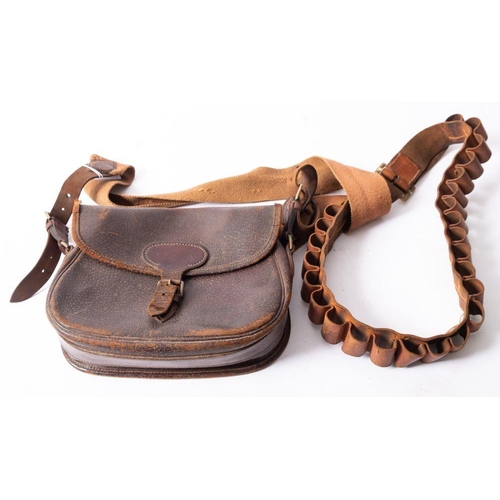 570 - A brown leather pigskin cartridge bag, together with a brown leather 12 bore cartridge belt. (2)