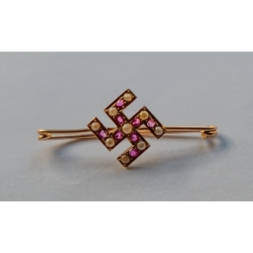 534 - A yellow metal Swastika brooch inset with sea pearls and rubies, 2.1g.