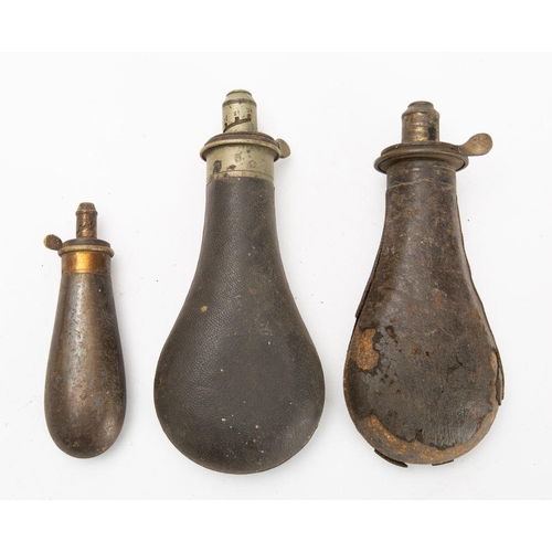 564 - Two leather covered powder flasks with dram measure spouts and a smaller copper powder flask (3)
