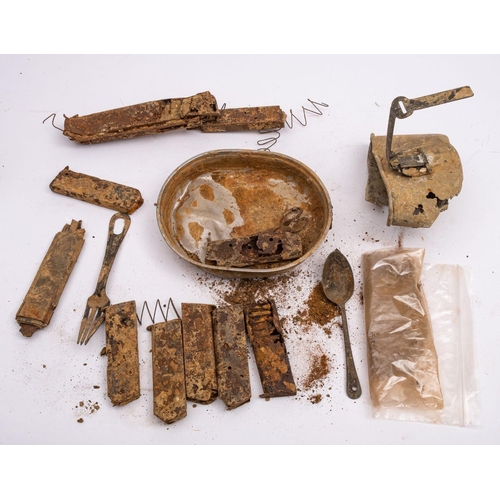 780 - A small collection of excavated and salvaged militaria, including empty gun clips, a fork and spoon ... 