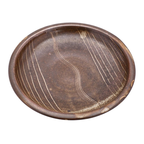 132 - *Bernard Leech [1887 - 1979] a stoneware shallow dish, of circular form with linear decoration on a ... 