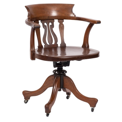 1065 - A late Victorian walnut swivel desk office armchair; the back with carved top rail and pierced centr... 