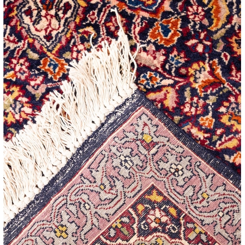 1174 - A Kashmiri rug, the indigo field with a central ivory circular medallion, all over arabesque designs... 