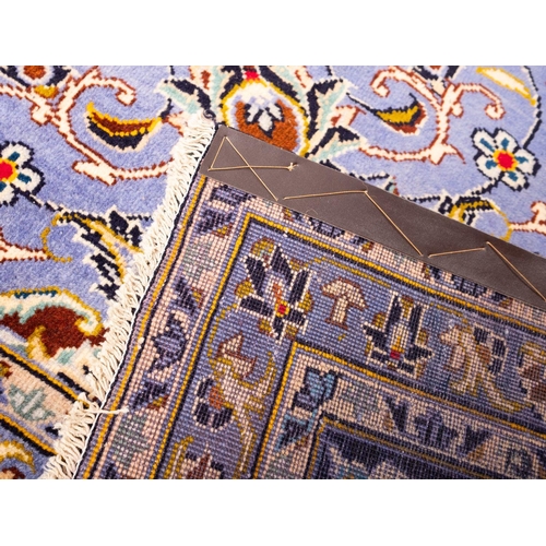 1179 - A Kashan carpet, the indigo cartouche field with a central powder blue and brown cartouche pole meda... 