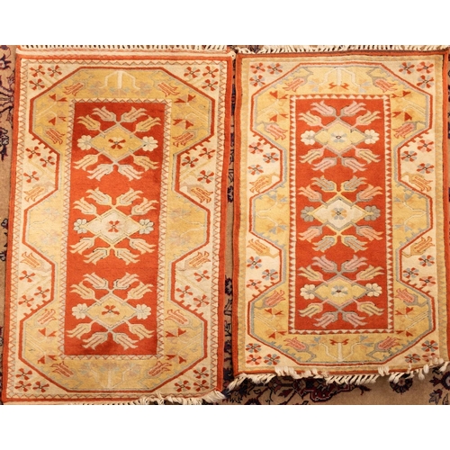 1184 - Four matching Melas rugs, the rust fields with triple lozenge and radiating stylised flowerhead meda... 