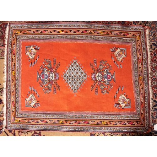 1188 - A Soumac flatweave rug, the brick red field with a central lozenge medallion flanked by urns of styl... 