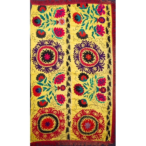 1201 - A North East Persian silk embroidered bed cover worked with a design of vases of flowers and roundel... 