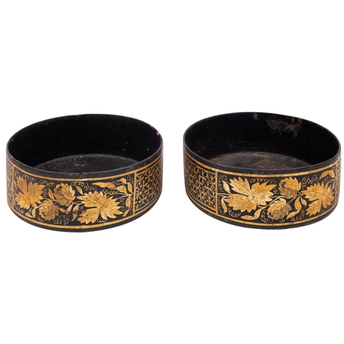 291 - A pair of Regency parcel gilt black papier mâché bottle coasters, circa 1815; decorated with grapevi... 