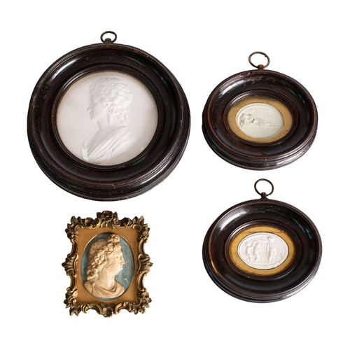 314 - A group of three Italian plaster cameos, early 19th century; all within stained wood moulding frames... 