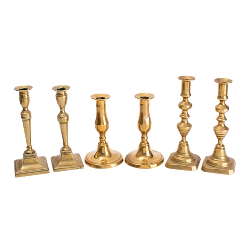 335 - A pair of 19th century brass candlesticks; with urn-shaped sconces of knopped stems and square bases... 