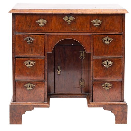 863 - A walnut and feather banded kneehole desk, 18th Century and later, the rectangular top with a moulde... 