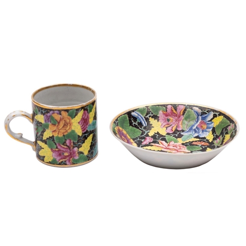 87 - A Chinese famille rose black ground coffee can and saucer enamelled with a 'tobacco leaf' design and... 