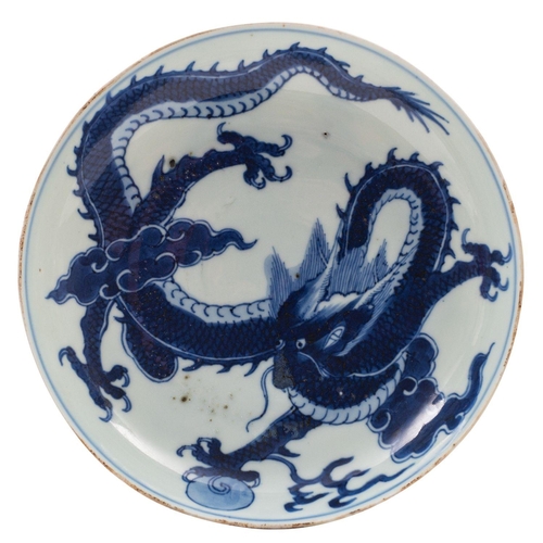 93 - A Chinese blue and white 'dragon' saucer dish the interior painted with a dragon clasping a sacred p... 