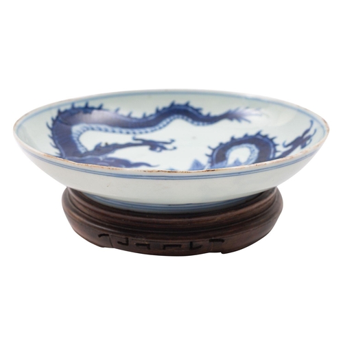 93 - A Chinese blue and white 'dragon' saucer dish the interior painted with a dragon clasping a sacred p... 