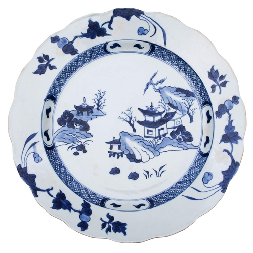 94 - A Chinese blue and white 'Nanking Cargo' dish with scalloped rim, painted with a 'willow pattern' la... 