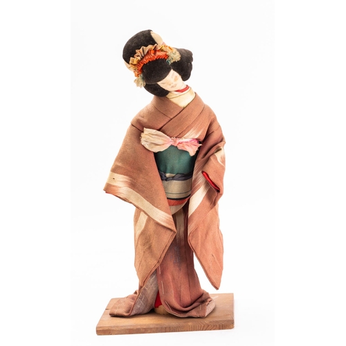 650 - A Post-War linen doll of a geisha, reputedly made from medal ribbons, in traditional style dress on ... 