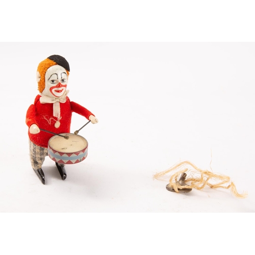 654 - A Schuco tinplate clockwork Drumming Clown, black felt beret over ginger hair and painted tinplate f... 