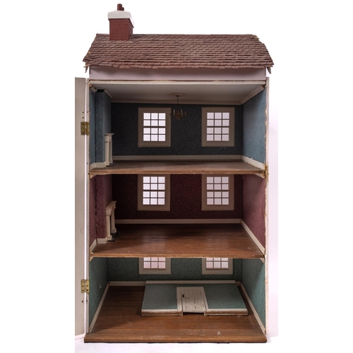 663 - A 20th century dolls house in the Georgian style, the three story opening front enclosing three room... 