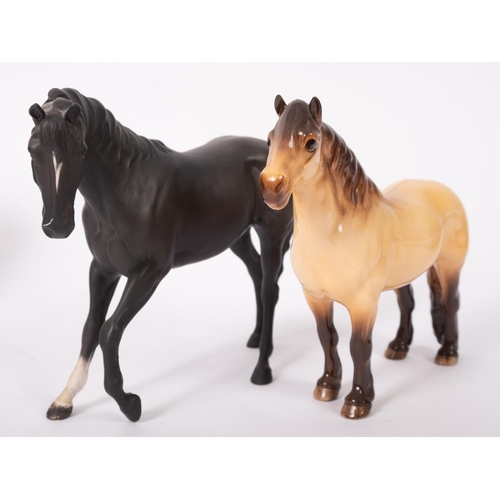 15 - A Beswick black matt glazed horse and a Bewsick Highland horse, the largest 17cm high overall