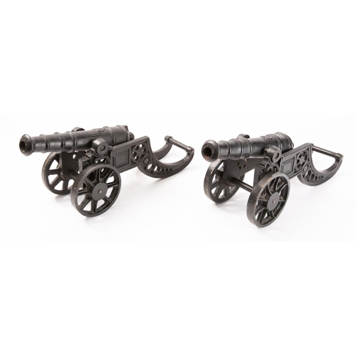 180 - A pair of cast iron model cannon, the 9 1/2 inch five stage barrels with harp motif and rounded cacs... 