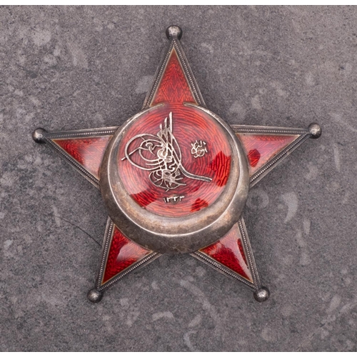 242 - A WWI Turkish Star of Gallipoli, German made red enamel on white metal with four rivet back and  pin... 