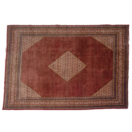 1061 - A Sarouk Mahal Carpet, the brick red octagonal field with an all over boteh design and central ivory... 