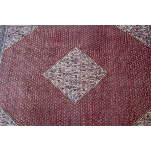 1061 - A Sarouk Mahal Carpet, the brick red octagonal field with an all over boteh design and central ivory... 