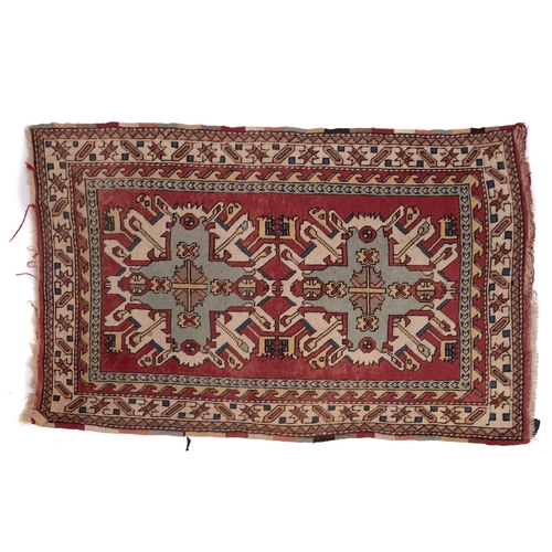 1064 - A Kurdish rug, the brick red field with ivory and pastel geometric medallions, enclosed by a main iv... 