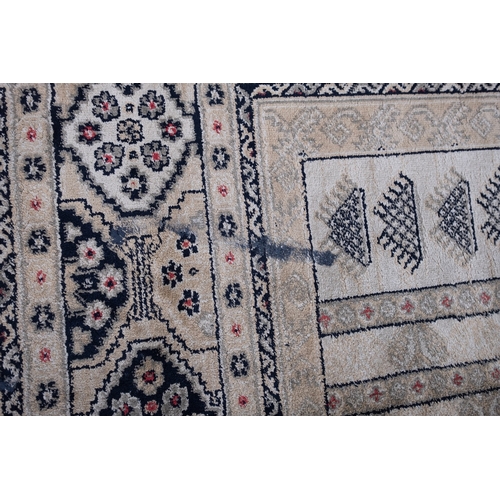 1064 - A Kurdish rug, the brick red field with ivory and pastel geometric medallions, enclosed by a main iv... 