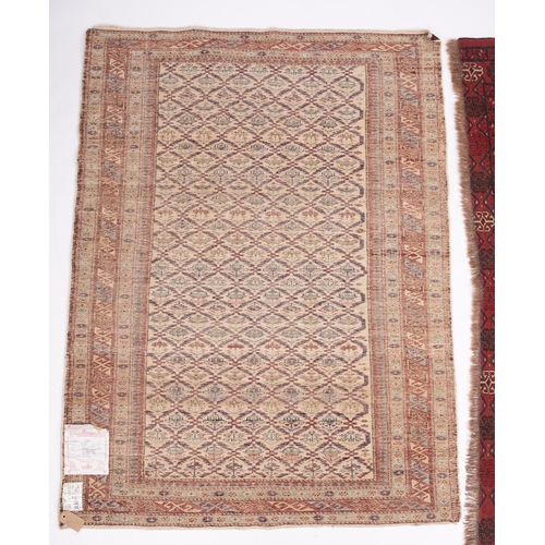 1065 - An Indo Persian rug, the ivory lattice field with geometric motifs, enclosed by a main wine hooked d... 