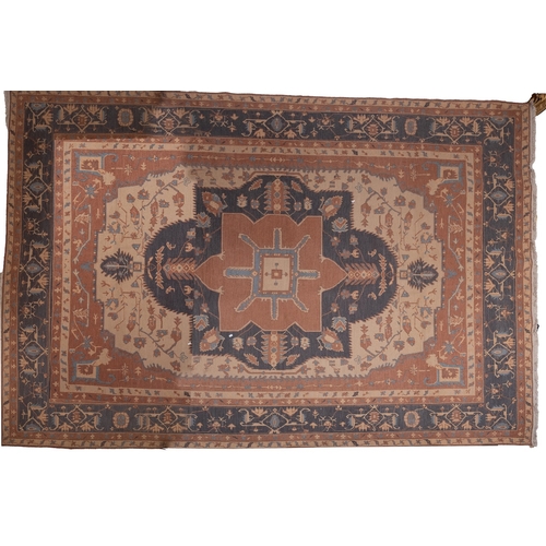 1067 - A Turkish carpet, the beige field with a central indigo, camel and beige geometric pole medallion, b... 