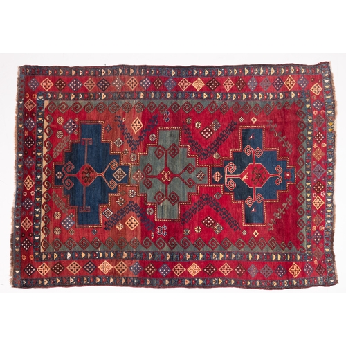 1079 - A Kasak rug, the wine field with triple indigo and pastel blue stepped cruciform medallions, surroun... 