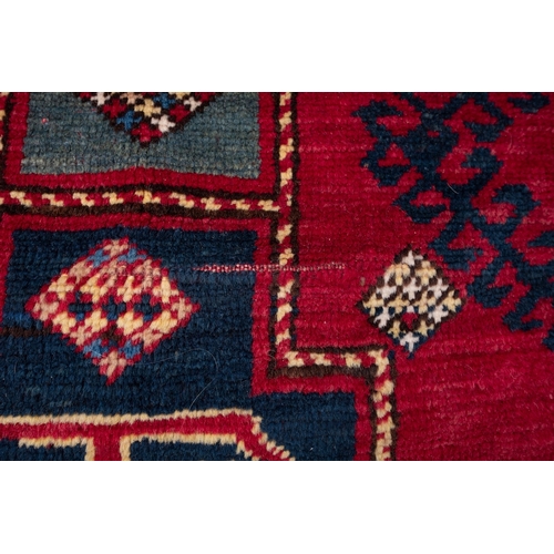 1079 - A Kasak rug, the wine field with triple indigo and pastel blue stepped cruciform medallions, surroun... 