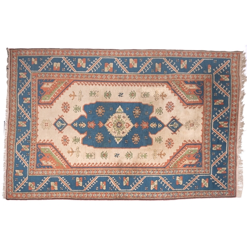 1082 - A Turkish carpet, the camel field with a central pastel blue geometric pole medallion with lozenge c... 