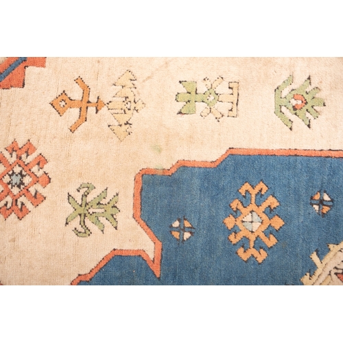 1082 - A Turkish carpet, the camel field with a central pastel blue geometric pole medallion with lozenge c... 