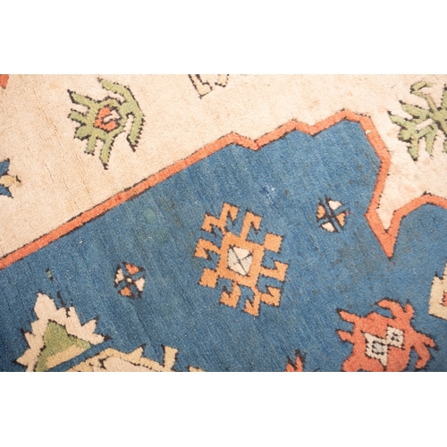 1082 - A Turkish carpet, the camel field with a central pastel blue geometric pole medallion with lozenge c... 