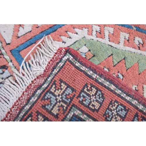 1082 - A Turkish carpet, the camel field with a central pastel blue geometric pole medallion with lozenge c... 